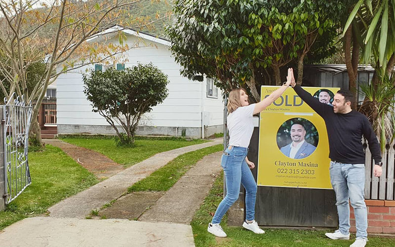 Kiwis high five after buying their first home